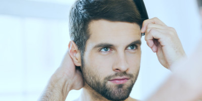 Zufriedener Patient mit vollem Haar nach einer Haaranalyse