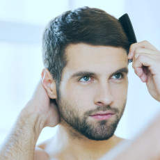 Zufriedener Patient mit vollem Haar nach einer Haaranalyse